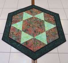 a quilted table topper sitting on the floor