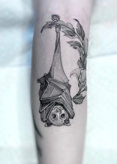 a tattoo on the leg of a person with a bat hanging from it's side