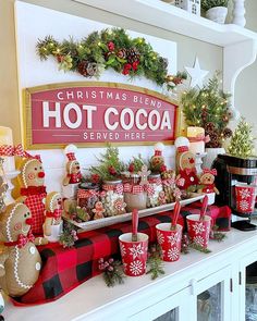 a decorated mantle with christmas decorations and hot cocoa cups on it, along with other holiday items