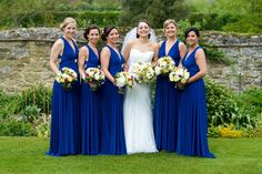 a group of women standing next to each other on top of a lush green field