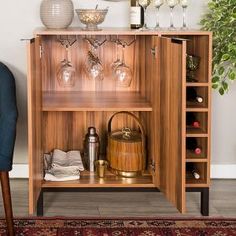 a wooden cabinet with wine glasses and other items on it, next to a blue chair