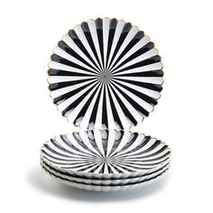 black and white plates stacked on top of each other in the shape of a fan