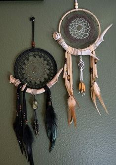 a dream catcher hanging on the wall next to a mirror with feathers and beads around it