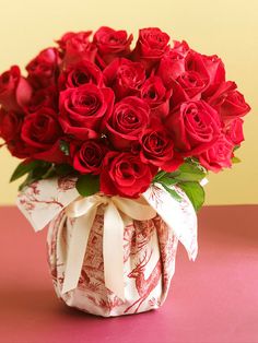 a vase filled with red roses on top of a table