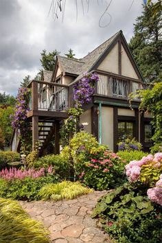 the house is surrounded by beautiful flowers and greenery