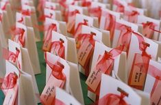 many small bags with red ribbons tied to them are lined up on the table together