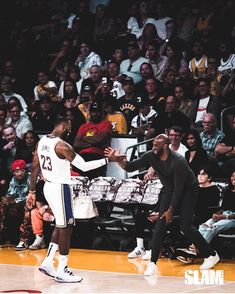 two basketball players shaking hands in front of an audience