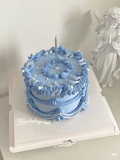 a blue cake sitting on top of a white table