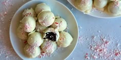 two white plates filled with desserts covered in sprinkles and powdered sugar