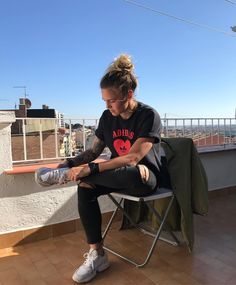 a woman sitting on top of a chair next to a window