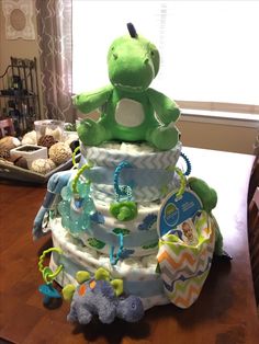 a diaper cake sitting on top of a table next to a teddy bear and other toys