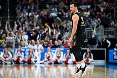 a basketball player walking on the court with his mouth open and people in the stands watching