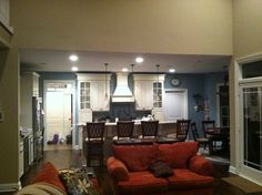 a living room filled with furniture next to a kitchen and dining room table in the background