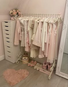 a closet filled with clothes and shoes next to a large white mirror on the floor