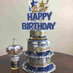 a birthday cake made out of beer cans on top of a table next to a bottle