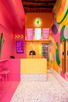 the interior of a brightly colored restaurant with neon colors