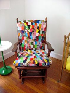 a patchwork chair with a green lamp next to it