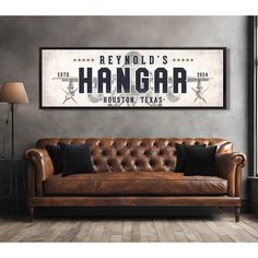 a leather couch in front of a gray wall with the words hangar on it