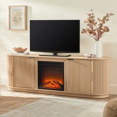 a flat screen tv sitting on top of a wooden entertainment center next to a fire place