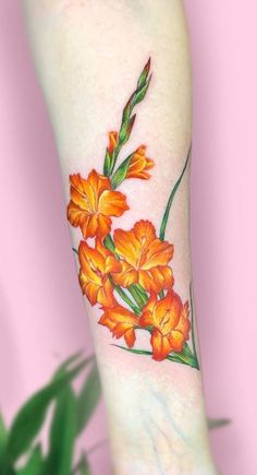 an orange flower tattoo on the arm