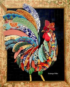 a colorful rooster made out of paper on top of a wooden stick in front of a brick wall