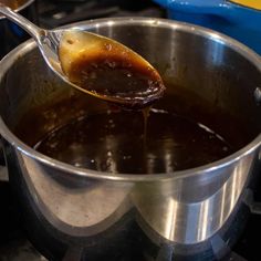 a spoon full of liquid sitting in a pot