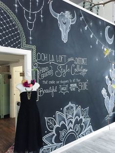 a blackboard with white writing on it and a dress hanging from the front door