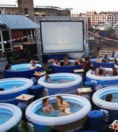 an outdoor movie is set up in the shape of giant tubs with people sitting inside