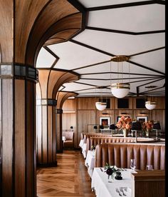 the interior of a restaurant with wood paneling and white tablecloths on tables