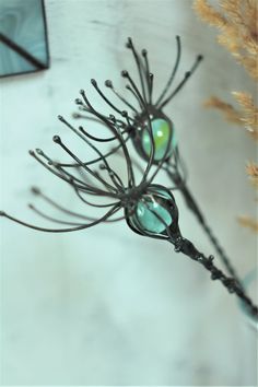 a close up of a plant with green glass drops on it's leaves and stems