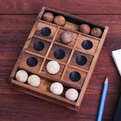 a wooden box filled with different types of balls and pencils on top of a table