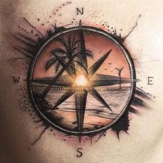 a man's chest with a compass tattoo on it and palm trees in the background