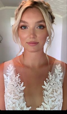 a woman with blonde hair and blue eyes wearing a white dress is looking at the camera