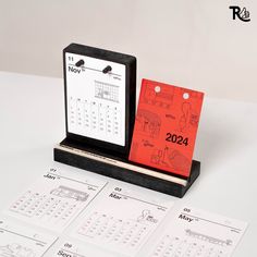 two calendars are sitting next to each other on a table with numbered sheets in front of them