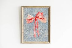 a painting with a red bow hanging on the wall