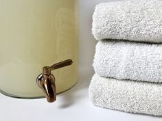 towels are stacked on top of each other in front of a canister with a handle