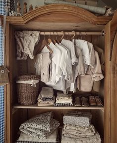 a wooden cabinet filled with lots of clothes