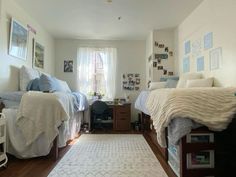 two beds in a room with pictures on the wall and a rug on the floor