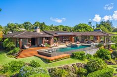 a house with a pool in the middle of it and lots of greenery around