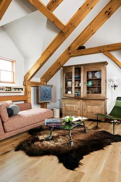 a living room filled with furniture and wooden beams