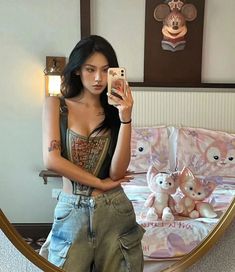 a woman taking a selfie in front of a mirror with stuffed animals on it