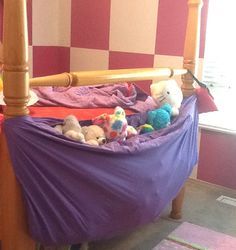 there is a purple bed with stuffed animals in it