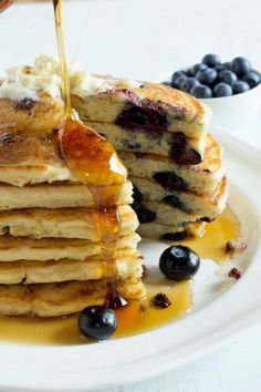 blueberry buttermik pancakes with syrup on a white plate