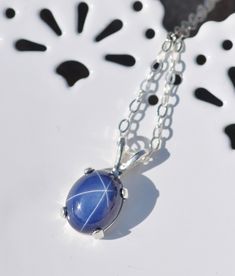 "A stunning new necklace made using a star sapphire gemstone. The sapphire is oval shaped and cabochon cut. It is excellent quality and set into a sterling silver prong setting. Lab grown Sapphire measures 10mm tall (just under 1/2\") while entire pendant is roughly 1/2\" tall. It hangs from sterling silver chain. Please choose desired chain length at checkout. Please see matching ring and earrings here: https://www.etsy.com/shop/hangingbyathread1?ref=search_shop_redirect&search_query=star+s Star Sapphire Gemstone, Sapphire Pendant Necklace, Oval Pendant Necklace, Sapphire Birthstone, Sapphire Necklace Pendants, Jewelry Dainty, Matching Ring, Star Sapphire, Sapphire Pendant