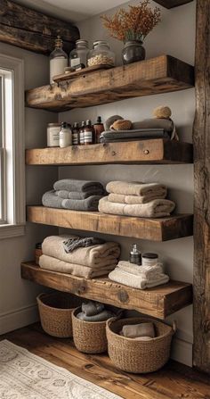 some shelves with towels and baskets on them in a bathroom that is very rustic looking