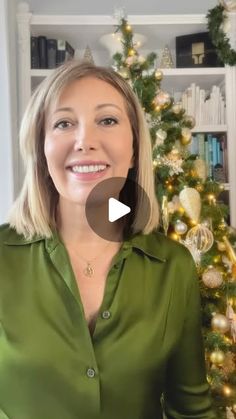 a woman standing in front of a christmas tree