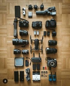 many different cameras and accessories laid out on the floor