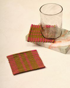 a glass sitting on top of a table next to a coaster