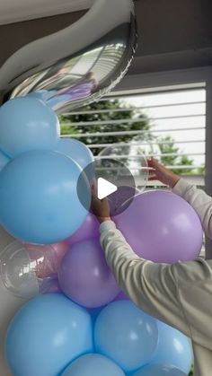 a woman is holding balloons in her hand