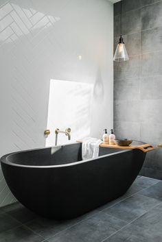 a large black bath tub sitting in a bathroom